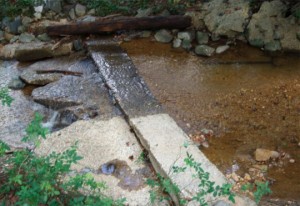The pipe went under this dam that would have caused extensive costs and time to the school to receive proper environmental permits.